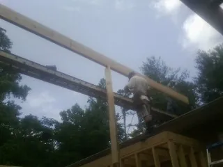 Carpenter setting a ridge beam over a new addition frame — Ice Dam Removal by Roofing Brothers in Horseheads