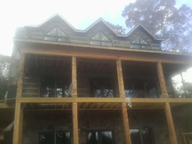 Dormers and porch framing on a large log home under construction — Roof Coating work by our crew in Horseheads