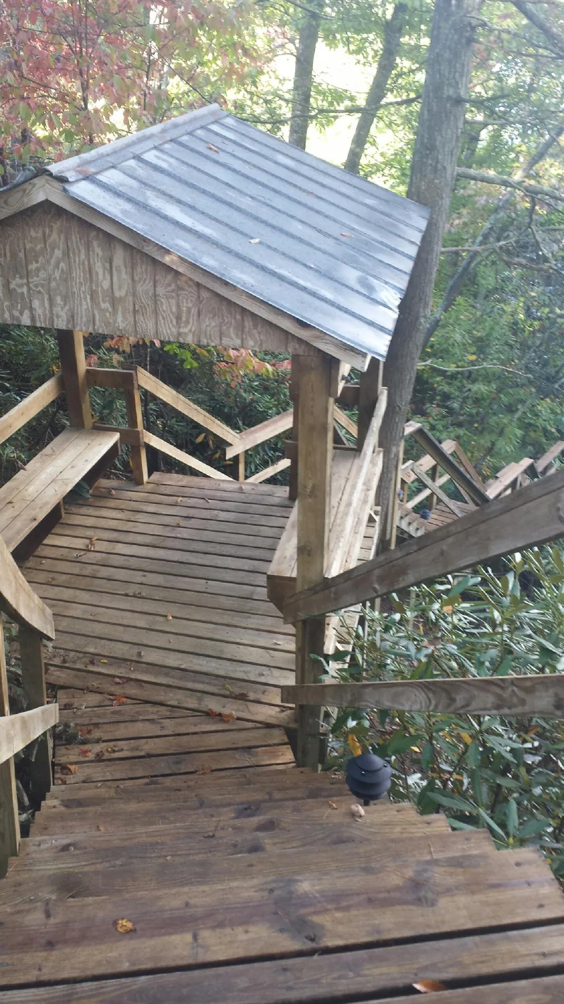 Metal roofed shelter over wooden steps on a wooded walkway — Skylight Repair & Installation work by our crew in Horseheads