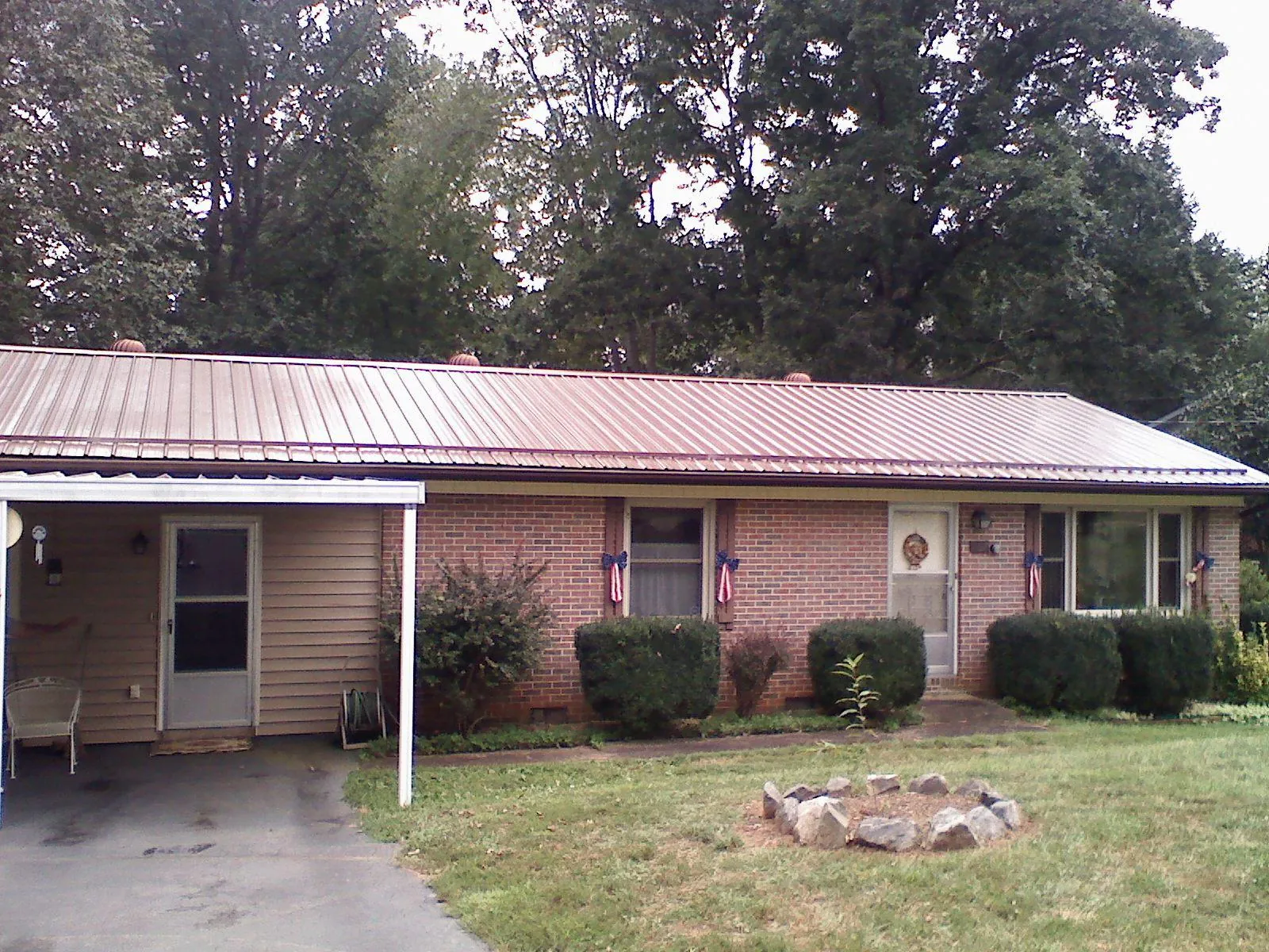 Bronze metal roof and carport on a brick ranch home — Roof Repair work by our crew in Horseheads